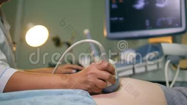 医生在检查孕妇时使用超声波设备。